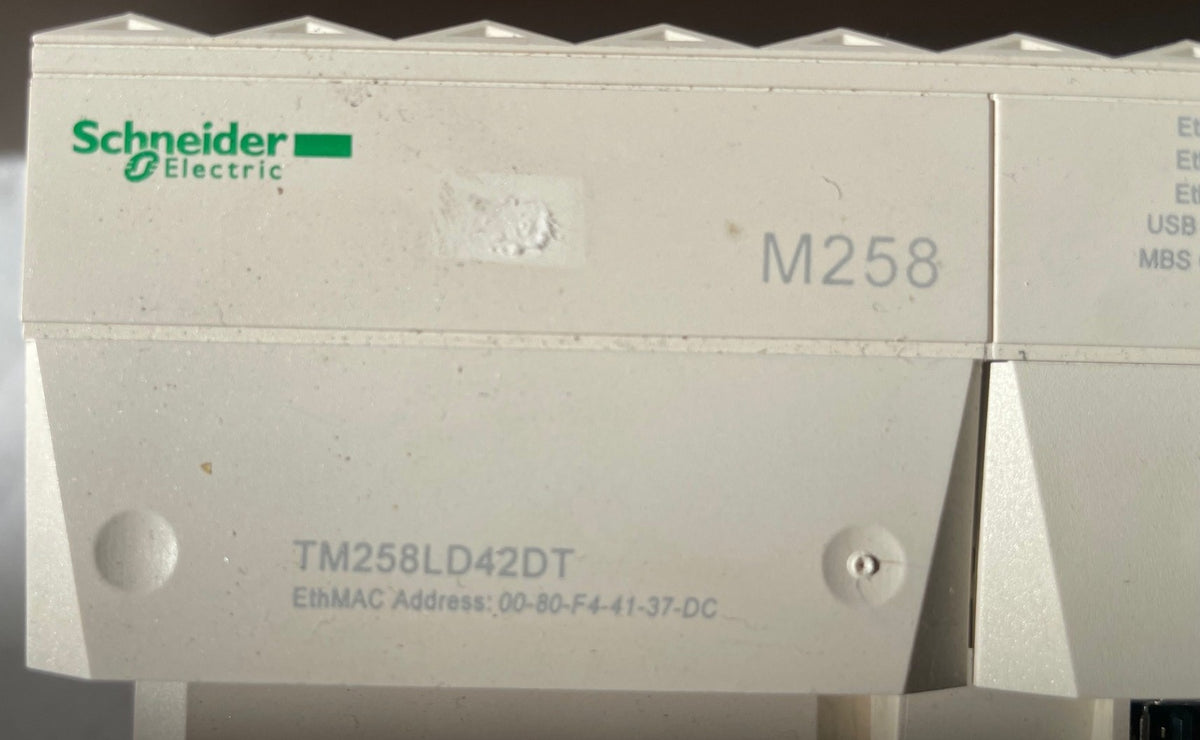 Schneider Electric industrial automation module, model TM258LD42DT, in a light gray plastic housing with green and white logo branding.