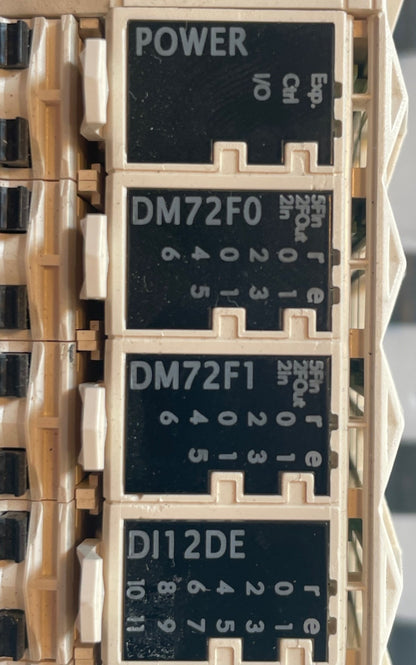 A close-up of industrial electrical relays, featuring black labels with white text for POWER, DM72F0, DM72F1, and DI12DE, mounted in a beige plastic housing. Schneider Electric TM258LD42DT Modicon M258 complete PLC and I/O module assembly