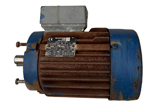 A used industrial electric motor with a blue painted metal body, a rusted brown ribbed housing, and a gray terminal box, shown against a textured off-white background.